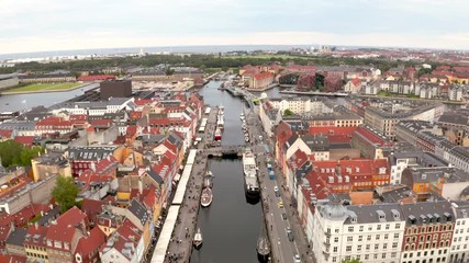 Wall Mural - Aerial view of Nyhavn at sunrise, with colorful facades of old houses and old ships in the Old Town of Copenhagen, capital of Denmark.