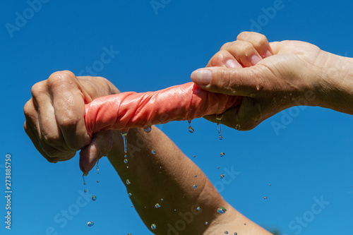 Hands squeze pink wet cloth. Tableau sur Toile