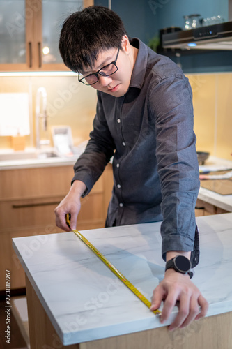 Asian Man Designer Using Tape Measure For Measuring White Granite