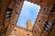 View from the courtyard of Siena town hall Palazzo Pubblico to Mangia Tower Torre del Mangia and blue winter sky, Tuscany, Italy