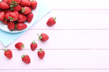 Wall Mural - Fresh strawberries in plate on pink wooden table