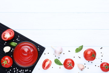 Ketchup in bowl with spices and garlic on wooden table