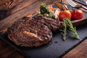 Wall Mural - grilled tomahawk ribeye steak on black stone plate