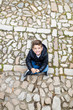 © Victor - Little kid seated on a cobblestone street