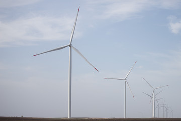 Wind warm on agricultural ground with cloudy sky in background