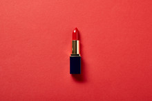Top View Of Single Tube Of Red Lipstick On Red