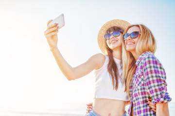 Wall Mural - Happy group of friend makes a selfie with a mobile phone.