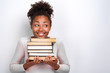 © speed300 - Portrait of happy nerd young girl holding books over white background. Back to school