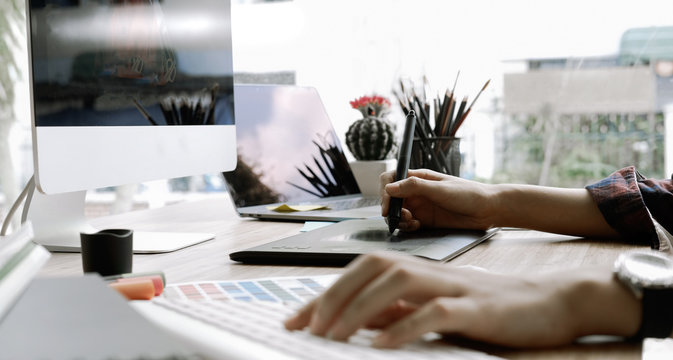 Attractive female graphic designer working at her desk in modern office