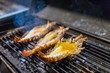 3 Large shrimps grilling on the grill. Smoke rising at night. Favorite Thai food. Selective focus.