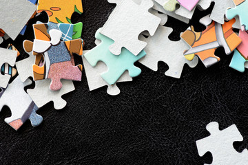 Children's puzzles scattered on a dark surface close-up