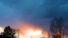 Bright Sunset Or Sunrise On A Dark Sky With Thunderclouds. Sunset Or Sunrise With Dark Clouds And Sunlight , Against The Light 