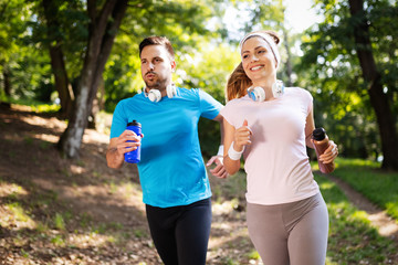 Happy couple jogging and running outdoors in nature