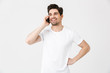 © Drobot Dean - Happy young man posing isolated over white wall background talking by mobile phone.
