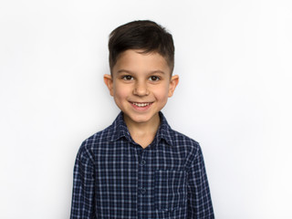 portrait of a cute little smiling boy in a blue shirt, isolated on a white background