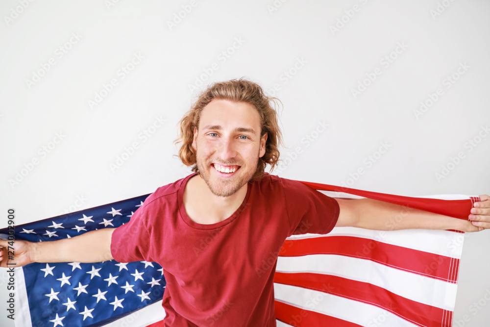 Happy young man with USA flag on white background. Independence Day celebration