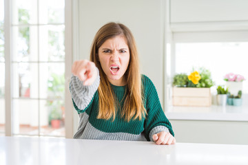 Young beautiful plus size woman wearing casual striped sweater pointing displeased and frustrated to the camera, angry and furious with you