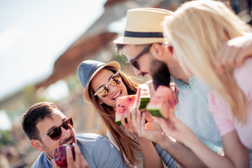 Wall Mural - Friends eating watermelons on the beach