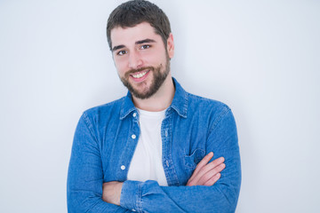 Young handsome hispanic man smiling at the camera with arms crossed looking happy and confident over isolated white background