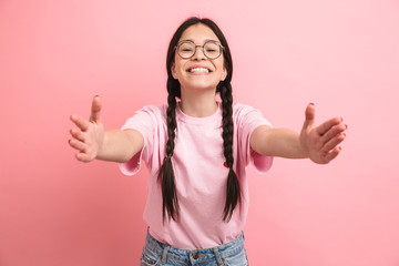 Canvas Print - Image of cute european girl with two braids wearing eyeglasses smiling and reaching her arms forward at camera