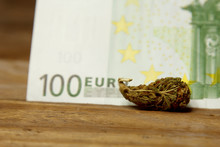 A Cannabis Bud Lies On A Hundred Euro Bill Close-up. Purchase And Sale Of Legalized Soft Drugs. Medical Cannabis Business Concept