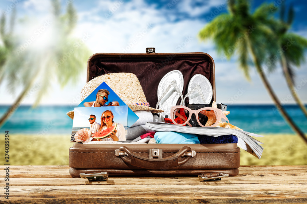 Stock-Foto „Summer suitcase ful summer stuff on beach and free space ...
