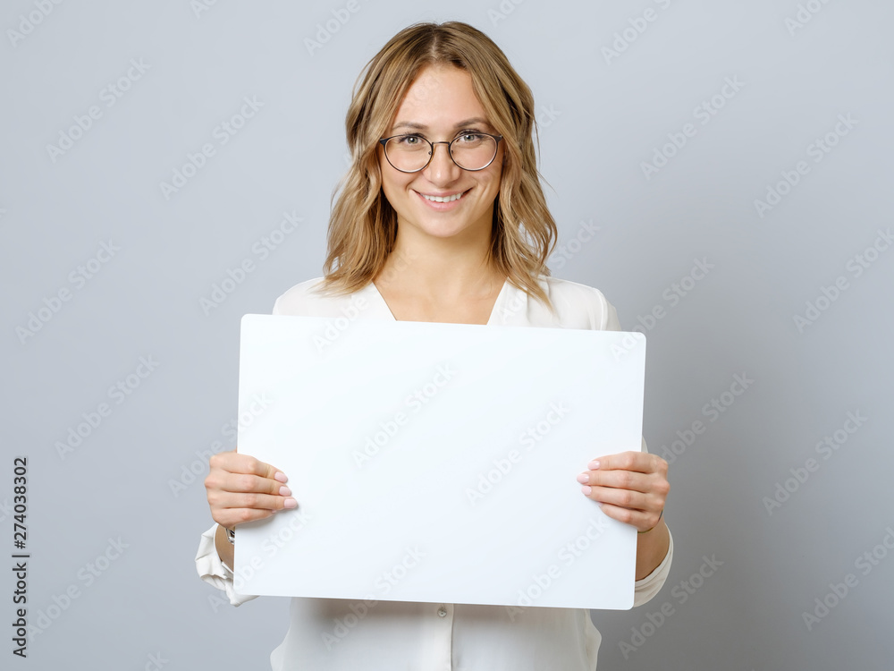 Pretty young woman holding empty blank board isolated - obrazy, fototapety, plakaty 