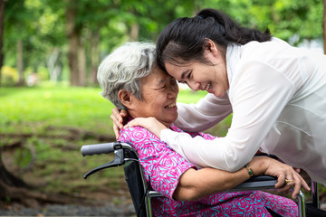 ,Happy beautiful asian senior people with adult woman hugging,smiling in summer,love of mother with her daughter in wheelchair at outdoor park in nature,mother’s day,family,love,elderly care concept