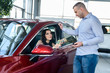 © RomanR - Woman offering australian dollar banknotes to dealer in showroom