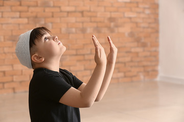 Little Muslim boy praying indoors