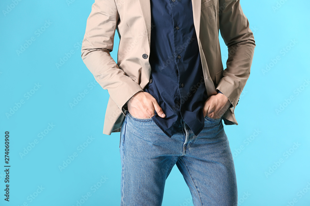 Stylish young man in casual clothes on color background