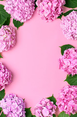 Fotomurales - Frame of Beautiful flowers of pink hydrangea with green leaves on pink background top view flat lay copy space. Flower card. Holiday, congratulations, happy mothers day. International Women's day.