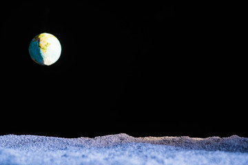sandy ground with blurred planet earth in space isolated on black
