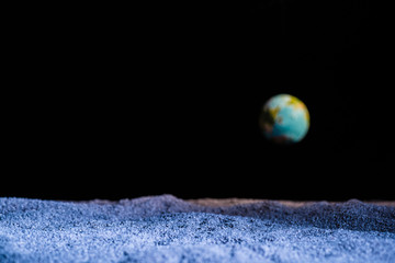 textured ground with blurred planet earth in space isolated on black