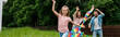 © LIGHTFIELD STUDIOS - panoramic shot of happy kid running with colorful kite near cheerful parents