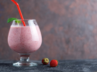 Strawberry smoothie or milkshake in a glass on the table. Healthy and delicious Breakfast