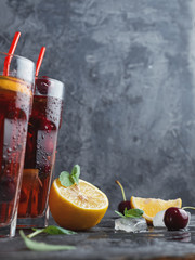Wall Mural - delicious summer cherry drink with lemon ice and mint on dark background with copyspace