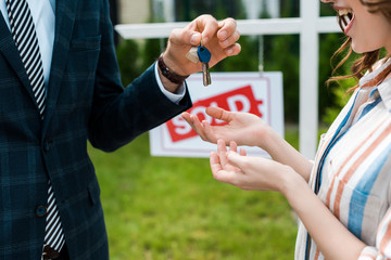 Wall Mural - cropped view of realtor giving keys to happy woman