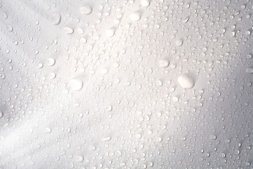 Abstract background image of close up shiny raindrops on white surface