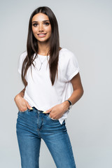 Wall Mural - Pretty smiling joyfully female with fair hair, dressed casually, looking with satisfaction at camera, being happy. Studio shot of good-looking beautiful woman isolated against blank studio wall.