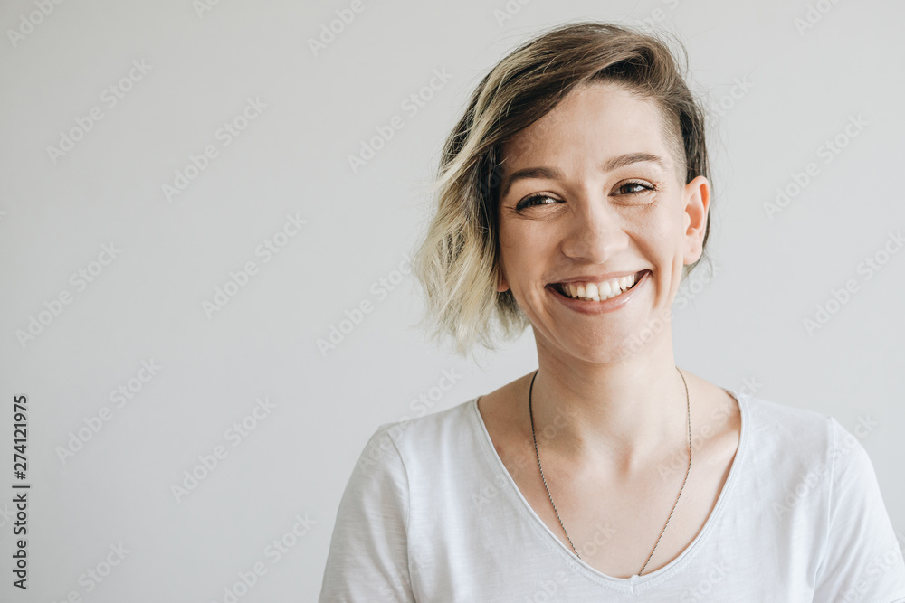 Beautiful young girl with short hair is smiling. - obrazy, fototapety, plakaty 