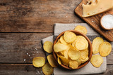 Fototapeta Mapy - Flat lay composition with delicious crispy potato chips on table, space for text