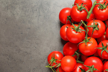 Heap of fresh cherry tomatoes on stone background, top view. Space for text