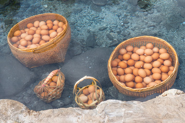 Close-up of boiled eggs soak in hot spring (cooked egg yolks and jelly egg), one of popular tourist activity when visiting Chae Son National Park the geothermal park in Lampang province of Thailand.