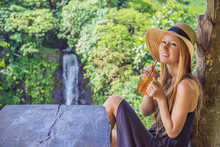Closeup Portrait Image Of A Beautiful Woman Drinking Ice Tea With Feeling Happy In Green Nature And Waterfall Garden Background