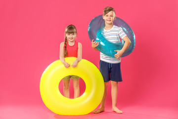 Poster - Cute little children with inflatable rings on color background