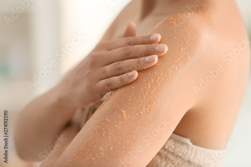 Fotomural Beautiful young woman applying body scrub at home, closeup
