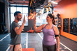 © Viacheslav Yakobchuk - Dark-haired plump woman giving high five to her fitness trainer