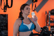 © Viacheslav Yakobchuk - Dark-haired plump woman drinking water after cardio training