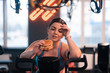 © Viacheslav Yakobchuk - Woman looking at burger while sitting on exercise cycle
